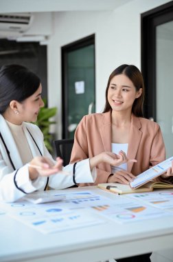 İki güzel Asyalı bayan ofis çalışanı finans projeleri hakkında konuşuyor ve tartışıyorlar. Meslektaşlar veya iş arkadaşları birlikte çalışma kavramı
