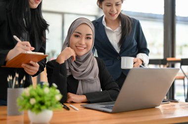 Güzel Asyalı genç Müslüman iş kadını ya da ofiste ekibiyle çalışan kadın ofis çalışanı..