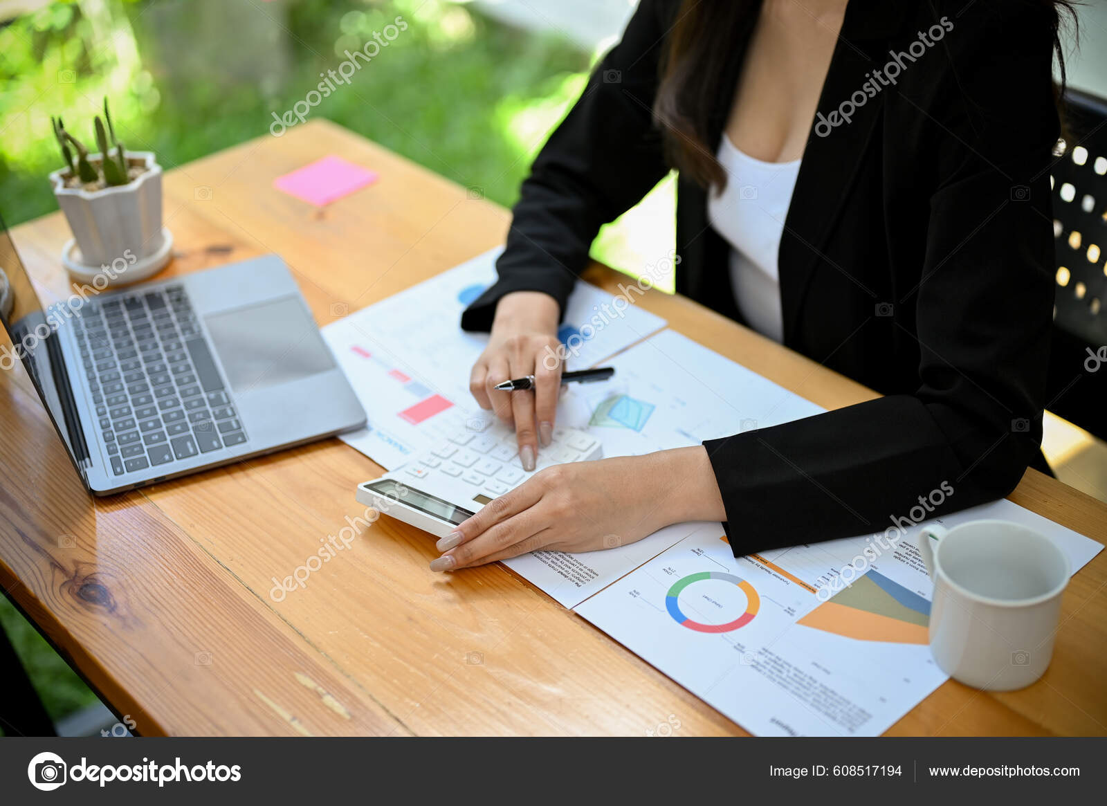 一位亚洲金融分析师或女性会计师使用计算器分析企业的财务和销售数据编写报告顶部视图——图库图片© BongkarnGraphic #608517194