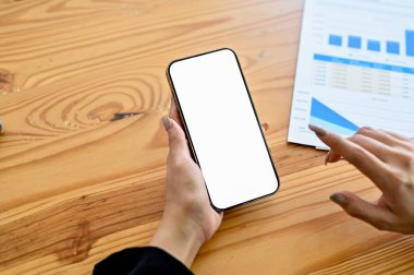 Ofis masasında akıllı telefonunu kullanan bir iş kadını, telefon beyaz ekran modeli. en üstteki görünüm