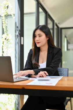 Portre, Güzel Asyalı finansal analist ya da kadın muhasebeci iş mali ve satış verilerini analiz ederek, rapor üzerinde çalışıyor.