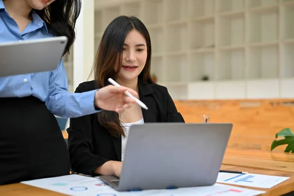 プロのアジア人ビジネスマンや女性の財務マネージャーは ラップトップで仕事の割り当てをチェックし 彼女の新しいスタッフを訓練します 切り取られクローズアップされ — ストック写真