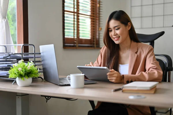 幸せと魅力的な千年のアジアのビジネスマンや女性マネージャーは デジタルタブレットを使用して 彼女の机の上に座っている — ストック写真