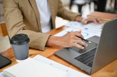 Akıllı Asyalı iş adamı ya da ofis masasında çalışan, dizüstü bilgisayarını kullanan, dizüstü bilgisayarında projesini yapan erkek patron. kırpılmış ve yakın plan resim