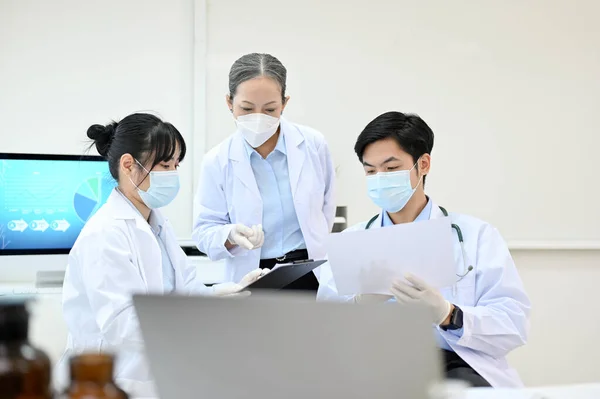 一队身穿白袍的亚洲专业科学家在实验室举行医学研究会议 医疗发展实验室概念 — 图库照片