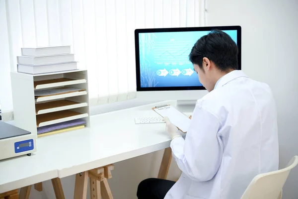 医生办公室办公室办公室的专业亚洲男医生 在剪贴板上检查病人的医疗报告或药物病史记录 — 图库照片