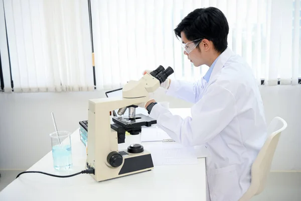 Belo Jovem Cientista Asiático Examinando Espécime Vírus Sob Microscópio Laboratório — Fotografia de Stock