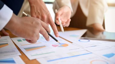 Yakın plan, bir grup profesyonel iş adamı en iyi yatırım planını tartışıyor ve oyluyorlar..