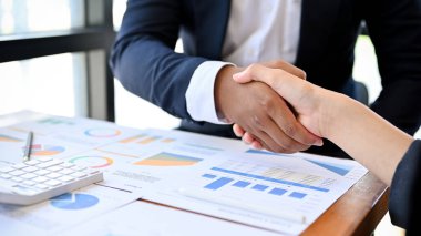 Profesyonel bir Asyalı kadın yönetici ya da iş kadını iş görüşmesi sırasında Afrikalı bir partnerle tokalaşıyor. Çeşitli iş adamları konsepti. kırpılmış resim