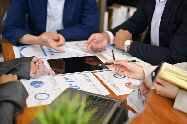 Group of professional financial consultant in the formal meeting, analyzing a financial investment turnover, looking the financial data on the report and tablet. cropped image