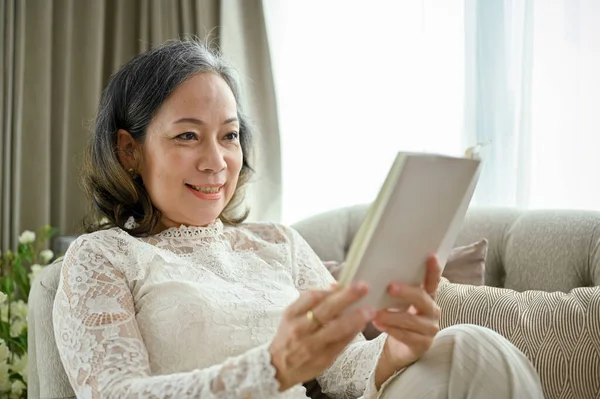 Šťastná Veselá Žena Asijského Věku Odpočívá Pohovce Svém Pohodlném Obývacím — Stock fotografie