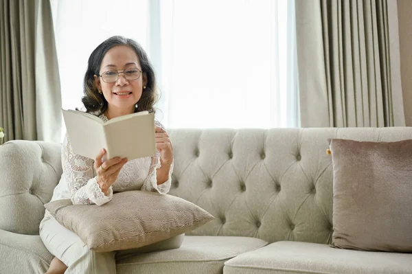 Okouzlující Asijská Žena Středního Věku Brýlích Sedí Útulné Pohovce Čte — Stock fotografie