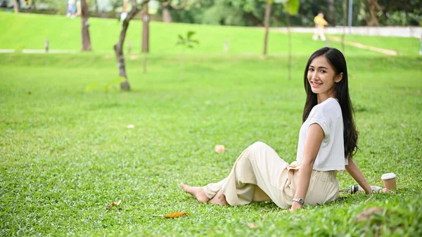 Привлекательная Великолепная Молодая Азиатка Повседневной Одежде Сидит Зеленой Траве Красивом — стоковое фото