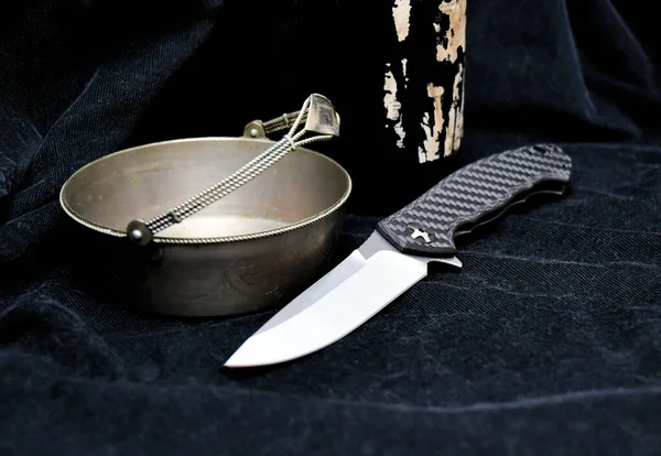 Folding knife cutting edge black carbone handle gray vintage silver plate macro blue denim background
