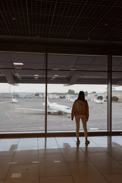 Νεαρή Κοπέλα Στέκεται Κοντά Στο Παράθυρο Στο Αεροδρόμιο Και Βλέποντας — Φωτογραφία Αρχείου