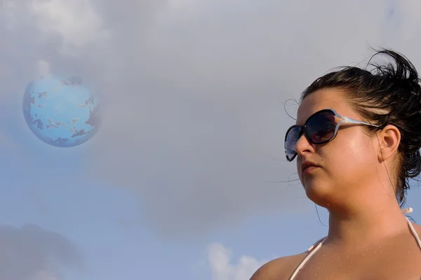 Chica mirando a la distancia con el planeta azul por encima de ella — Foto de Stock