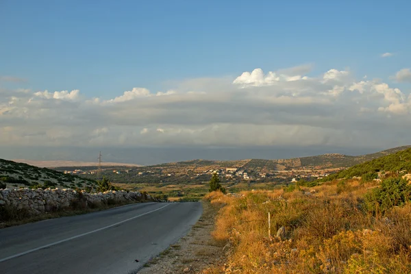 Tepe üzerinde küçük bir köy olan boş ada yol — Stok fotoğraf