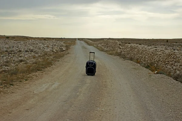 Kufr na osamělé prašné silnici-koncepce — Stock fotografie