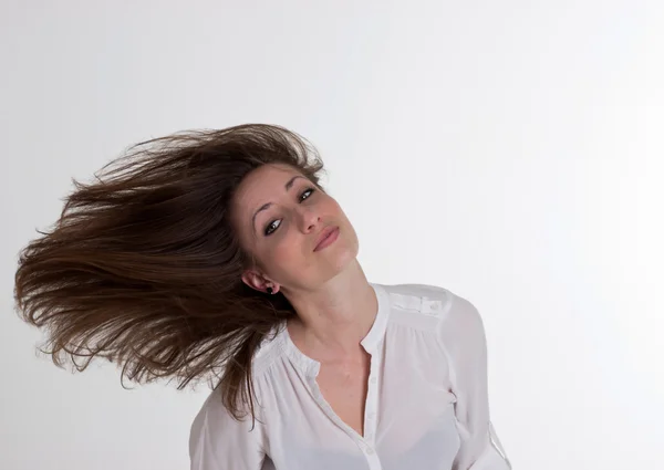 Mulher está soprando seu cabelo isolado no fundo branco — Fotografia de Stock