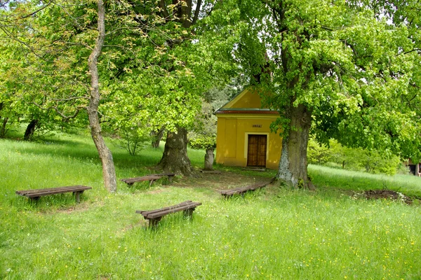Capela sub copacii și băncile mari de var — Fotografie, imagine de stoc