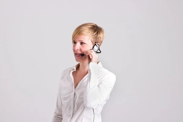 La mujer despachadora se comunica con los auriculares — Foto de Stock