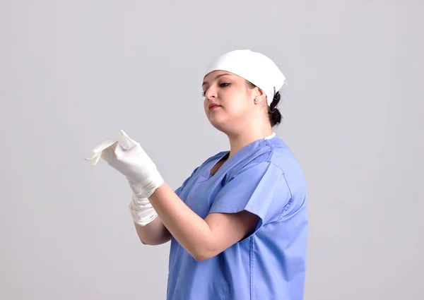 Mujer doctor está tomando una cirugía guantes — Foto de Stock