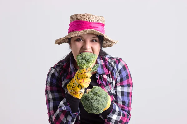 Trädgård kvinna i Livorno lastrum är bita en broccoli — Stockfoto