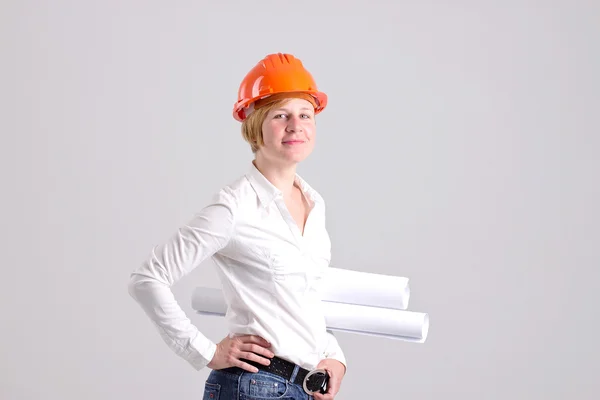 Archictress con casco de seguridad naranja y planes arquitectónicos — Foto de Stock