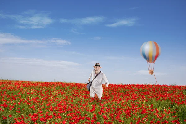 Člověk se prochází červená makové pole — Stock fotografie