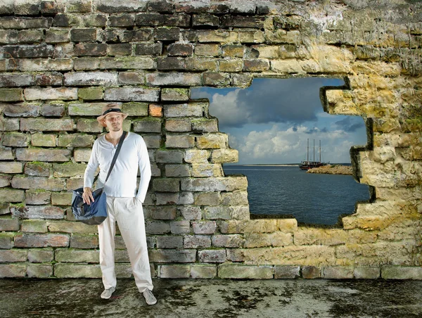 Muž s leghorn stojí před cihlová zeď — Stock fotografie