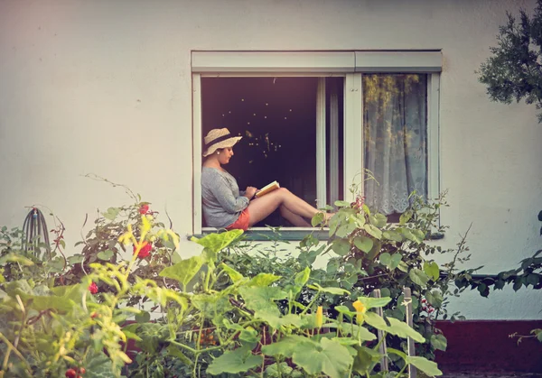 Chica está leyendo en ventana vieja —  Fotos de Stock