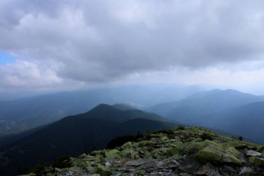 Karpat Dağı 'nın tepesi Khomyak ve etrafındaki dağların ve bulutların manzarası.