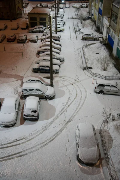 Pokryte Śniegiem Samochody Zaparkowane Nocy Dziedzińcu Wieżowca Śnieg Wiruje Świetle — Zdjęcie stockowe