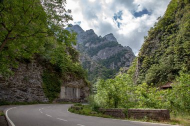 Yeşil bitkilerle kaplı dağların arasında kavisli bir yol... Kötü bir gün..