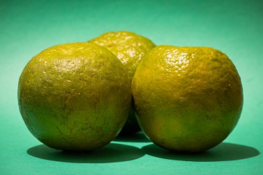 Birlikte tatlı portakal manzarası. Yeşil arkaplanda Kamala portakalları.