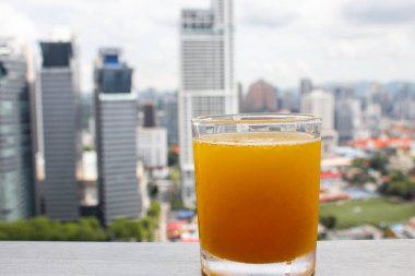 Yüksek katlı bir bardakta taze sıkılmış portakal suyu.
