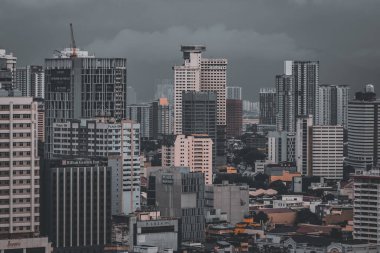 Kuala Lumpur, Malezya - Haziran 09 2022: Malezya 'nın Kuala Lumpur şehrinin göbeğindeki bulutlu bir günde yüksek binalar. Kuala Lumpur 'daki gökdelenlerin görüntüsü