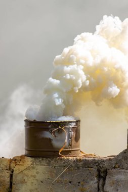 Taktik eğitim sırasında yıkılan tuğla duvardaki duman bombası. İşaretleme cihazı olarak, hedef veya iniş alanı işaretleme cihazı olarak ya da askeri birim hareketleri için bir tarama aracı olarak kullanılır.