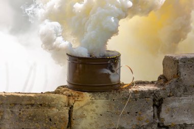 Taktik eğitim sırasında yıkılan tuğla duvardaki duman bombası. İşaretleme cihazı olarak, hedef veya iniş alanı işaretleme cihazı olarak ya da askeri birim hareketleri için bir tarama aracı olarak kullanılır.