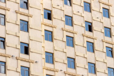 Şehir geçmişi. Çok sayıda benzer penceresi olan modern çok katlı bir ofis binasının ön cephesi. Alt manzara, kapatın. Modern apartman dairesi konsepti