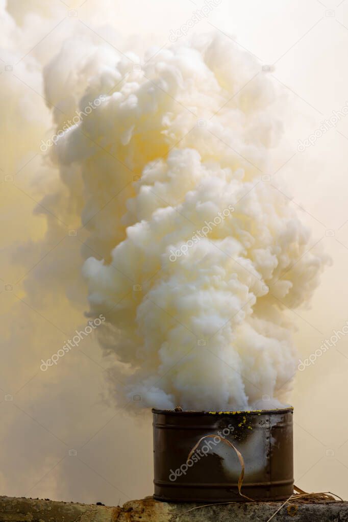 The fuming smoke grenade during tactical training. Used as signaling device, target or landing zone marking device, or as a screening device for military unit movements. Selective focus, blurred shot