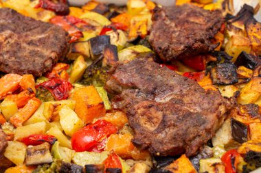 Fırında fırında, baharatlı patates, dolma biber, kabak, balkabağı ve brokoli ile pişirilmiş domuz parçaları. Ev yapımı yemek, özgün arka plan, yakın plan.