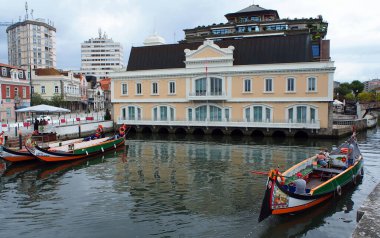 Akşamın erken saatlerinde belediye binasının yanındaki kanala park etmiş ikonik gondollar, Aveiro, Portekiz - 15 Eylül 2021