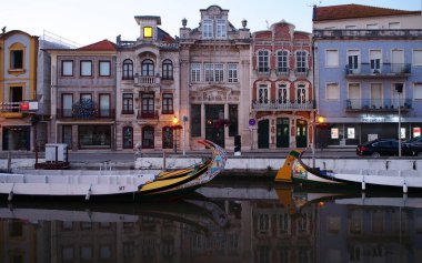 Gondollar eski kasaba merkezindeki kanala park etmiş, akşam aydınlatması manzarası, Aveiro, Portekiz - 15 Eylül 2021