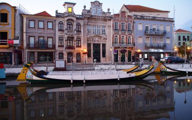 Akşamın erken saatlerinde Merkez Kanal 'a park etmiş ikonik gondollar arka planda Art Nouveau konutları, Aveiro, Portekiz - 15 Eylül 2021