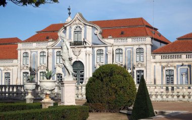 Queluz Sarayı 'nın Hanging Garden' ındaki heykeller ve manikürlü bitkiler, arka plandaki balo salonu kanadı, Lizbon, Portekiz yakınlarındaki 18. yüzyıl barok kraliyet konutu - 23 Aralık 2021