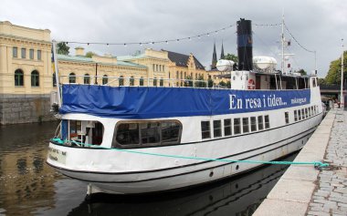 Vintage excursion tourist boat, King Carl Gustaf, moored by the Fyris River embankment, Uppsala, Sweden - July 5, 2019