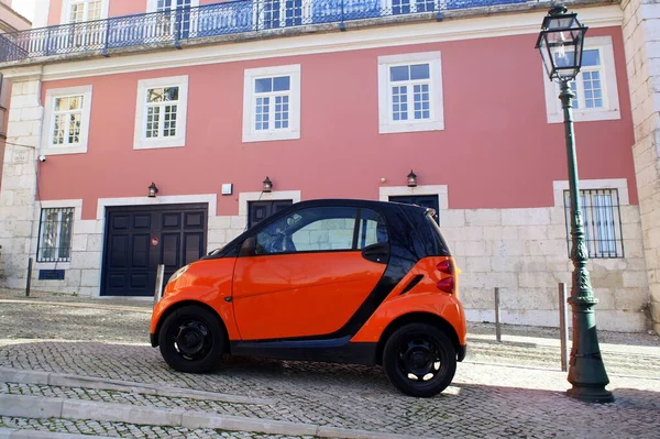 Lizbon, Portekiz 'deki Cobblestone caddesinde turuncu mikro araba - 18 Aralık 2021