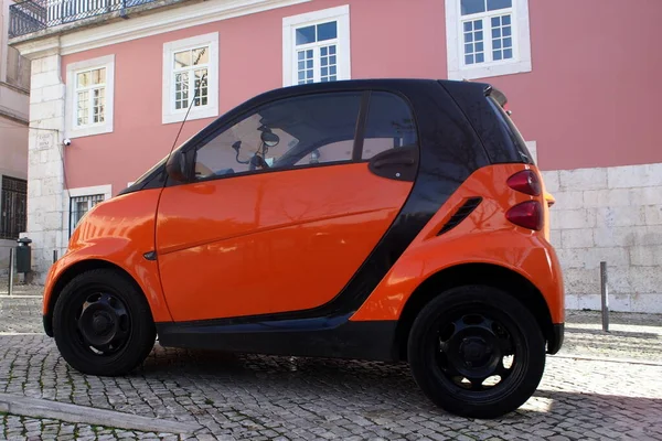 Lizbon, Portekiz 'deki Cobblestone caddesinde turuncu mikro araba - 18 Aralık 2021