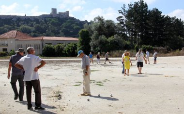 Petanque oyuncuları güneşli bir günde, Obidos Kalesi arka planda, Obidos, Portekiz - 16 Eylül 2021